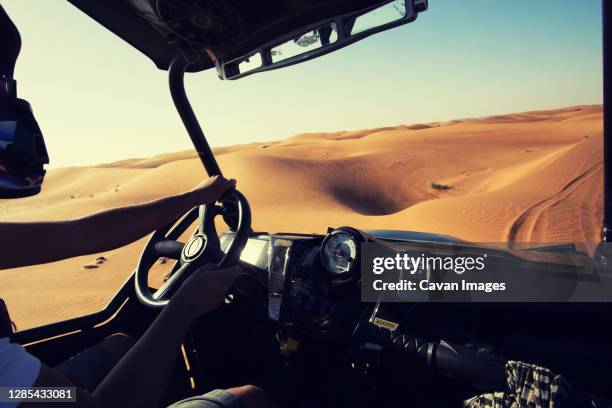 driving quad bike, buggy at dubai desert sand dunes - arab driving stock-fotos und bilder