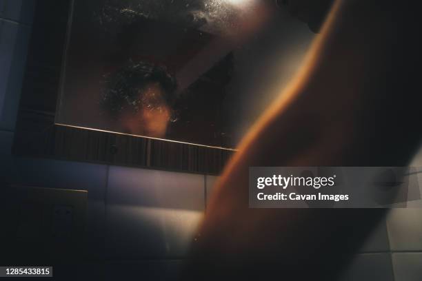 man in front of the mirror after a bath - luchtvochtigheid stockfoto's en -beelden