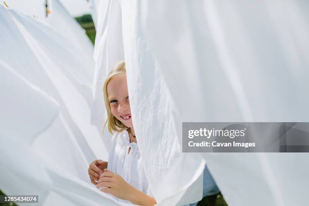 little village girls playing hide and seek - the little white dress stock-fotos und bilder