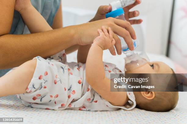 mom putting inalator to her baby - respiratory system stock pictures, royalty-free photos & images