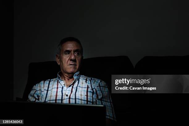 elderly man browsing laptop in dark room - old man dark stock pictures, royalty-free photos & images