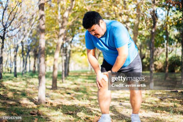 at man suffering from knee injury - fat legs stock pictures, royalty-free photos & images