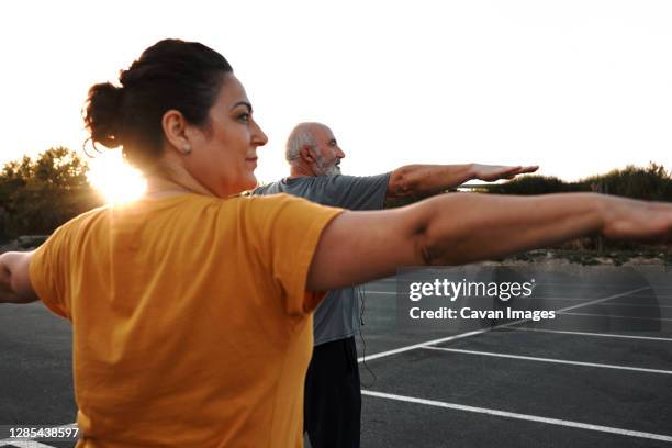 a middle-aged couple are doing yoga exercises - overweight stock pictures, royalty-free photos & images