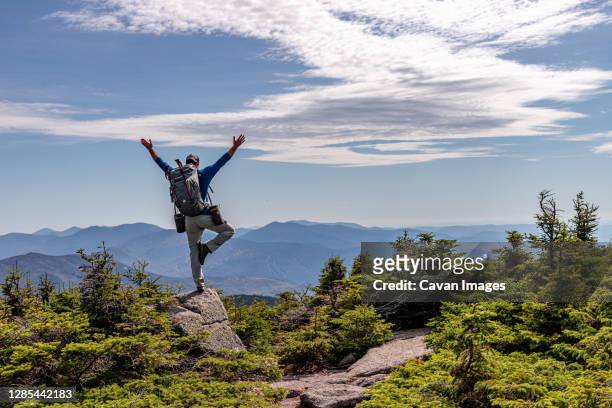 man practicing yoga balancing pose at top of mountain. - ホワイト山脈 ストックフォトと画像
