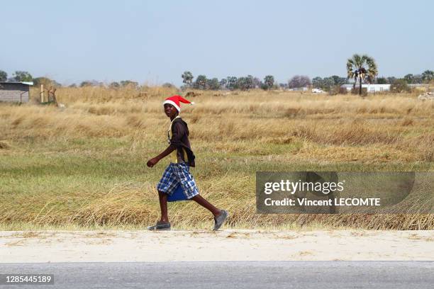 Adolescent avec un bonnet de Noël sur la tête sur le long d'une route, le 14 aout 2017, Ondangwa, Namibie.