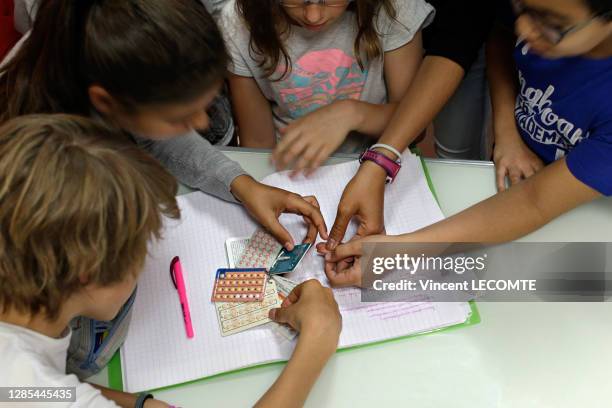 Un groupe de collégiens et de collégienne examine des plaquettes de pilule et un stérilet lors d'un cours d'éducation sexuelle en classe de sixième,...