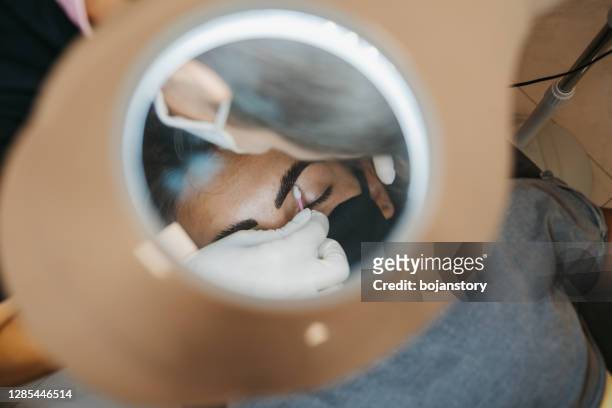 professionelle make-up-künstler malt augenbrauen an kunden - brow lamination stock-fotos und bilder