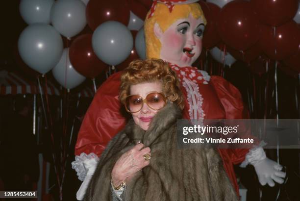 American actress and comedian Lucille Ball wearing sunglasses with a fur coat, with Ball holding the coat closed at her neck, circa 1980.