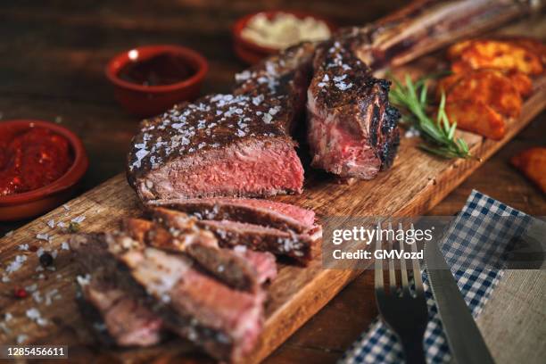 tomahawk steak with country potatoes - rib eye steak stock pictures, royalty-free photos & images