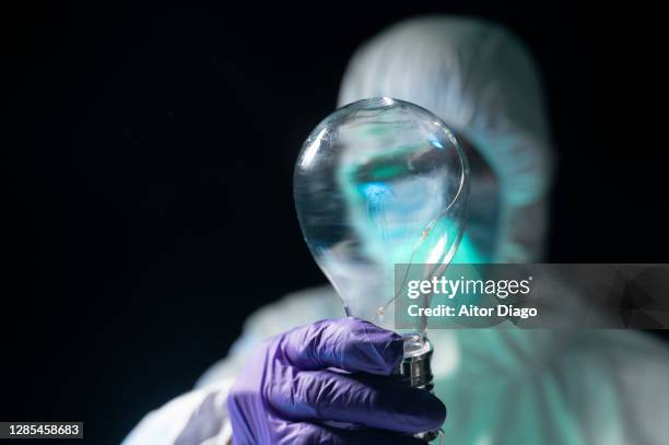 innovation! a scientist holds a light bulb. focus on the foreground. - earth rights imagens e fotografias de stock