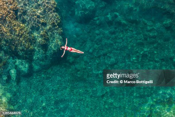 young woman relaxing on a natural pool - islande fotografías e imágenes de stock