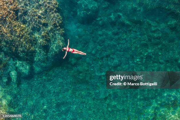 young woman relaxing on a natural pool - swimming pool top view stock pictures, royalty-free photos & images