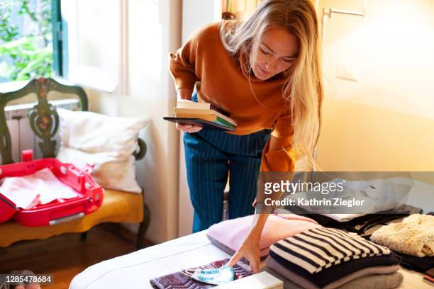 woman packing her suitcase to go on a trip - arrangiare foto e immagini stock