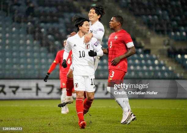 Takumi Minamino of Japan celebrates with Genki Haraguchi of Japan after scoring his team's first goal during the international friendly match between...