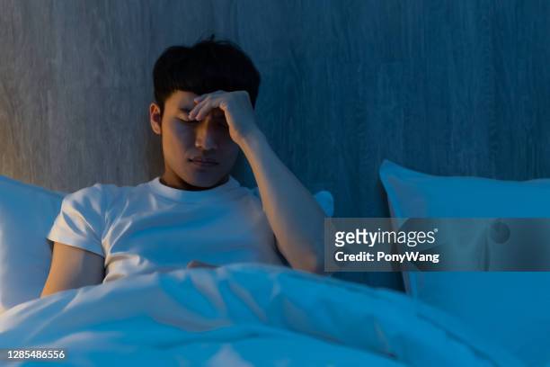 ongerust gemaakte mens op bed - korean man stockfoto's en -beelden