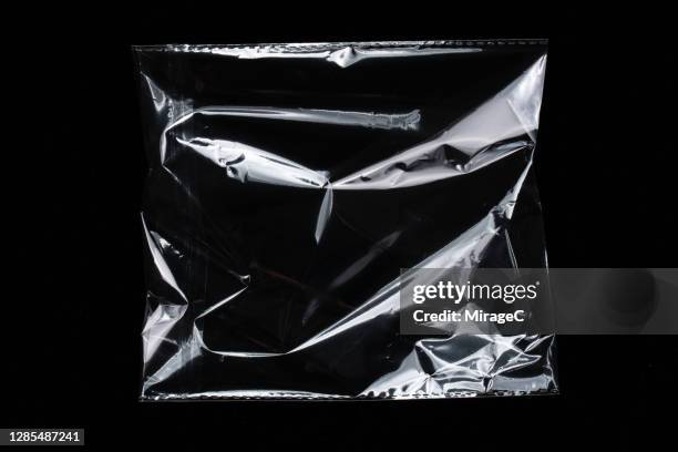 crumpled transparent plastic bag reflecting white lights - transparent bag stock pictures, royalty-free photos & images