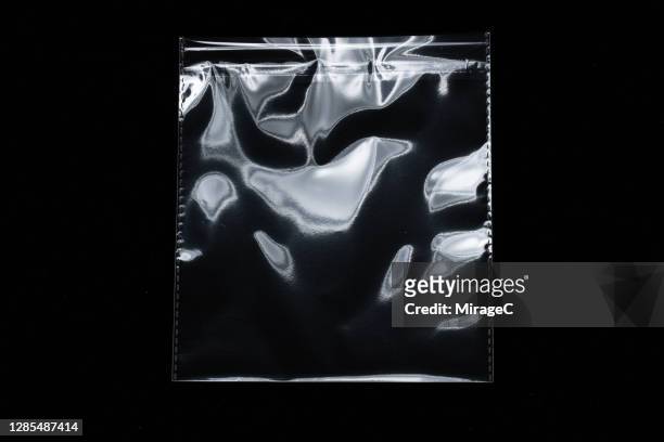 new transparent plastic bag reflecting white lights - coprire foto e immagini stock