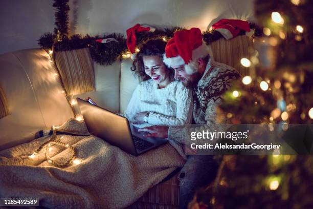 couple picking movie to watch on christmas eve - christmas movie stock pictures, royalty-free photos & images