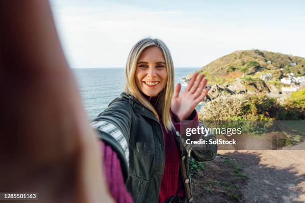 het nemen van een selfie aan de kust - blonde woman selfie stockfoto's en -beelden