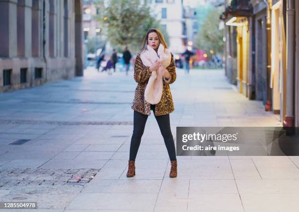 portrait of beautiful young woman wearing leopard print winter coat on the street. fashion concept - patrón de leopardo fotografías e imágenes de stock
