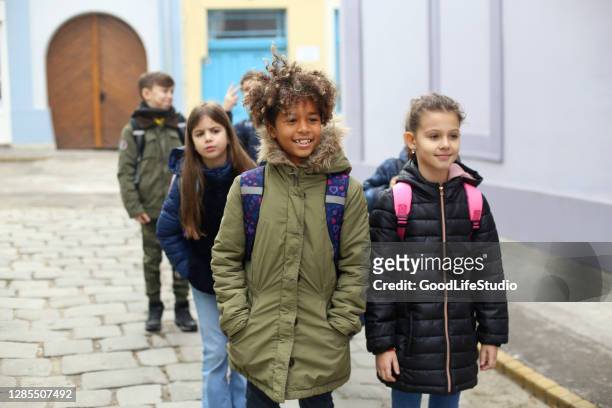 bambini che camminano a scuola - solo bambini foto e immagini stock