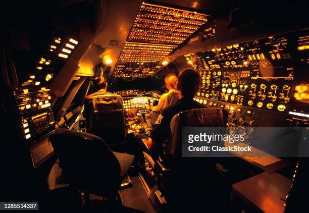 1990s Three Anonymous Men Pilots Air Crew Sitting In Boeing 747-200 Flight Simulator Practicing Flying