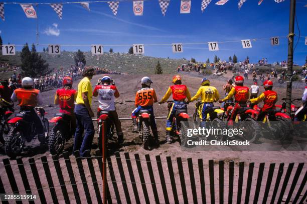 1980s Back View Starting Lineup At Motorcycle Dirt Track Cross Country Race Drivers Riders Wearing Helmets And Safety Gear