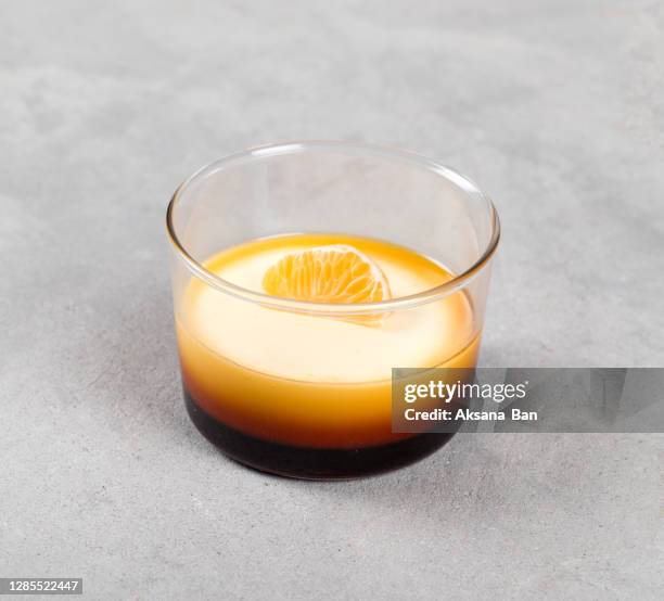 dessert flan, cream caramel with tangerine in a glass cup on a light background - flan tart fotografías e imágenes de stock