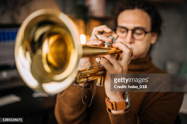 young stylish musician with dreadlocks playing trumpet - brass instrument stock pictures, royalty-free photos & images