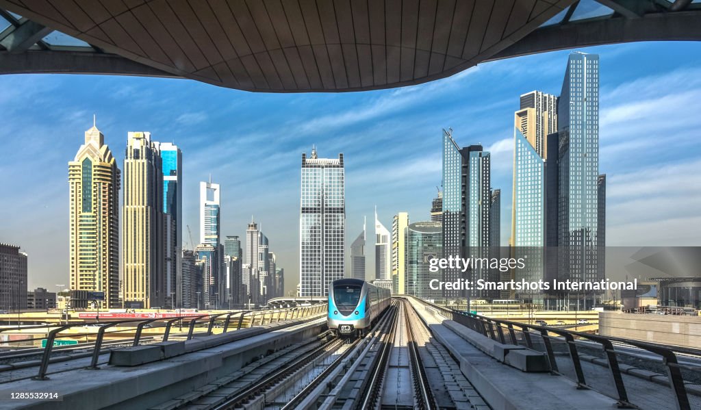 Driverless metro with futuristic city skyline on background in Dubai, UAE