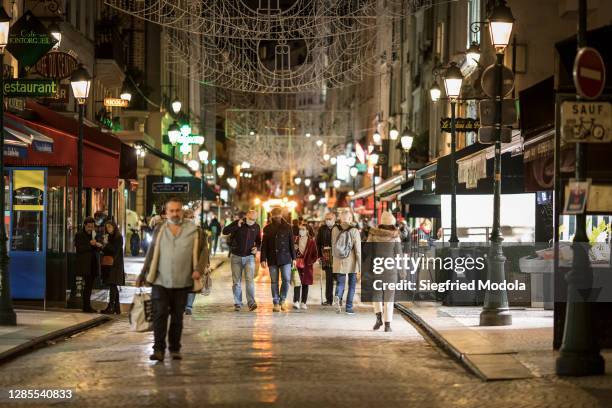 Pedestrians walk in Rue Montorgueil, a street in the 1st arrondissement and 2nd arrondissement lined with restaurants, cafés, bakeries, fish stores...