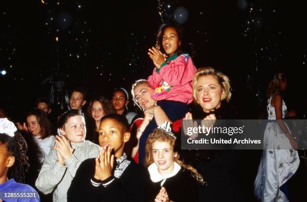 Moderatorin Marijke Amado mit Kindern der Mini-Playback-Show bei einer Benefiz-Gala in Düsseldorf, Deutschland 1991.