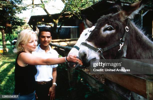 Michael Dierks und Diana Staehly, beide Schauspieler, füttern zwei Esel, Deutschland 1999.