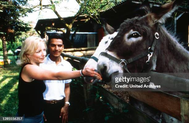Michael Dierks und Diana Staehly, beide Schauspieler, füttern zwei Esel, Deutschland 1999.