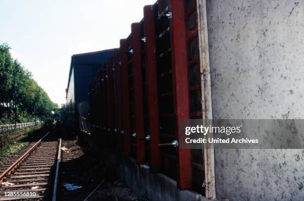Mauer als Sichtschutz vor dem Liegeplatz des Schiffes der Kelly Family am Auenweg im Hafen von Köln Mülheim, Deutschland 1995.