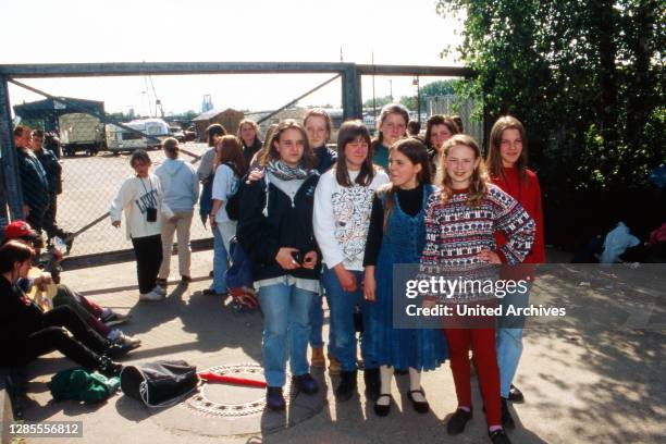 Fans stehen wartend vor der Mauer als Sichtschutz am Liegeplatz des Schiffes der Kelly Family am Auenweg im Hafen von Köln Mülheim, Deutschland 1995.