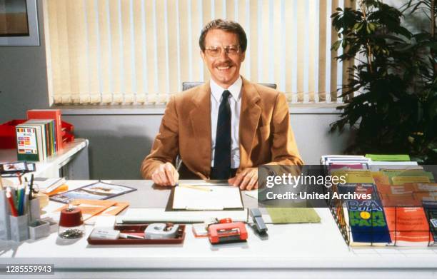 Gernot Endemann als Versicherungsvertreter seriös mit Anzug und Krawatte am Schreibtisch in der ZDF-Sendung "Rente aber sicher", Deutschland 1990.