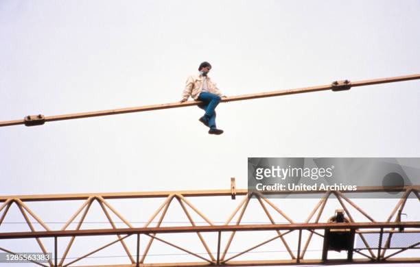 Armin Schröder, ein in Hamburg einschlägig bekannter "Klettermaxe", auf einem Kran in der Innenstadt von Hamburg, Deutschland 1989.