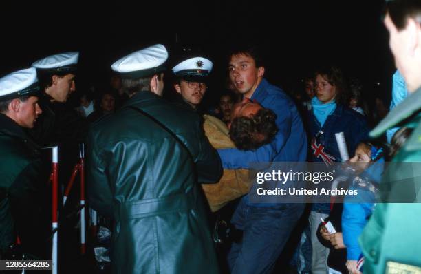 Prinz Charles und Prinzessin Diana beim Besuch in Deutschland 1987, hier: Bergung eines ohnmächtigen Fans durch Freunde und Polizei.