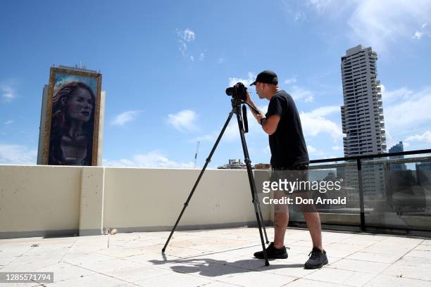 Man records video footage of the portrait from the Zenith building on November 14, 2020 in Sydney, Australia. A team of 11 artists have been working...