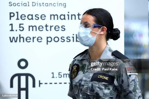 Members of the Australian Defence Force assist with passenger arrivals from Brisbane on Qantas flight QF937 at Perth Airport on November 14, 2020 in...