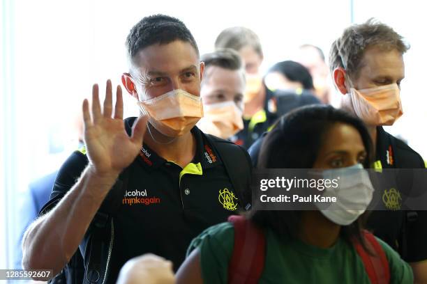 West Australian cricket player Shaun Marsh waves to waiting family members prior to G2G verification after arriving from Adelaide on Qantas flight...