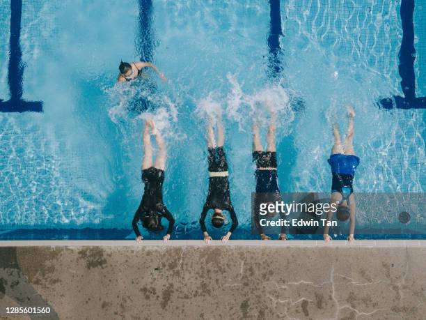dronemening direct boven aziatische chinese zwemmer die been het bespatten water bij poolside oefent die door de zwemmende bus wordt geleid - leren zwemmen stockfoto's en -beelden