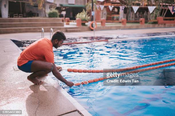 asiatische indische trainer binden schwimmspur marker - rettungsschwimmer stock-fotos und bilder