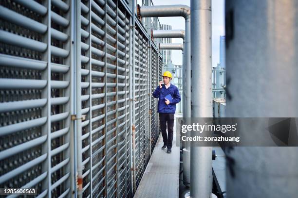 een mannelijke ingenieur onderzoek bij pipeline - cooling tower stockfoto's en -beelden