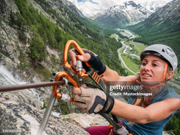 登山岩を上るフェラータ通りの若い女性 - カラビナ ストックフォトと画像