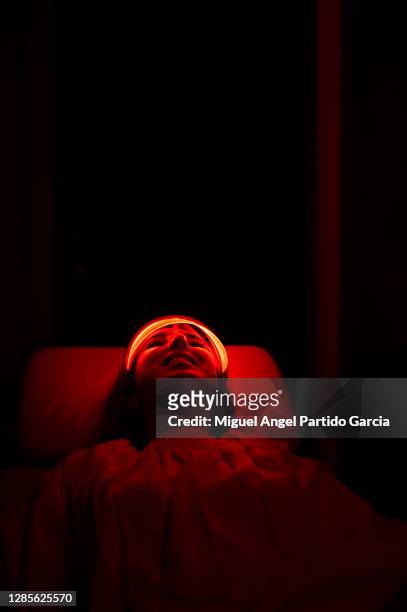 young woman having red led light facial therapy treatment in beauty salon. beauty and wellness - led mask stock pictures, royalty-free photos & images
