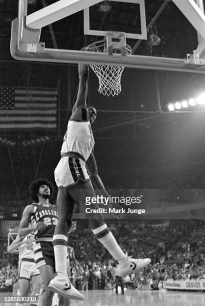 David Thompson of the Denver Nuggets slam dunks the ball as Rowland Garrett watches during a game against the Cleveland Cavaliers at McNichols Arena...