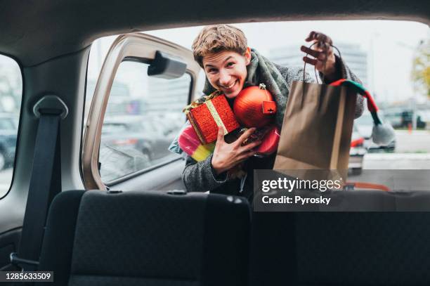 un giovane bello che fa shopping di natale - car wrapping foto e immagini stock
