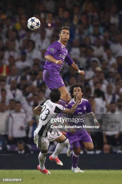 Cristiano Ronaldo of Real Madrid leaps to head the ball clear form Dani Alves of Juventus as Marcelo of Real Madrid looks on during the UEFA...